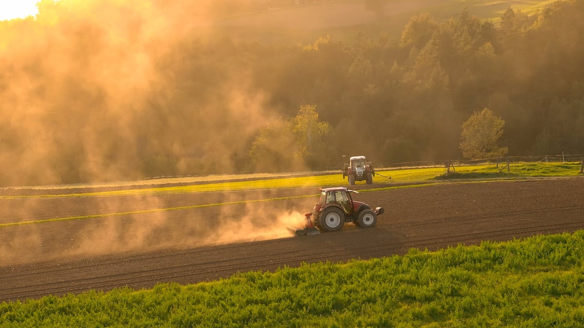 Farmers preparing field with tractors