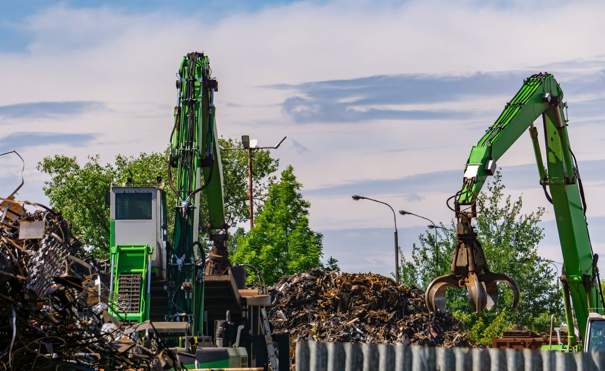Scrapyard with material handling machines and metal piles